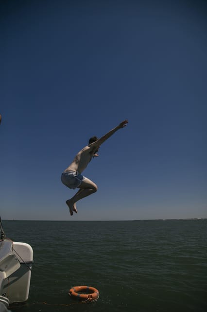 Lisbon: Catamaran Boat Party with Music, Open Bar & Dives - The 25 de Abril Bridge and the open river